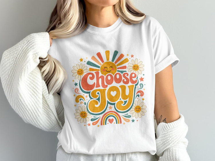White t-shirt with "Choose Joy" text and retro sun, daisies, stars, and rainbow design.