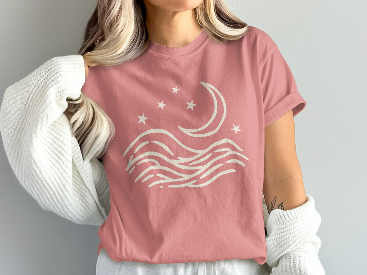 Pink t-shirt with cream moon, stars, and wave graphic.