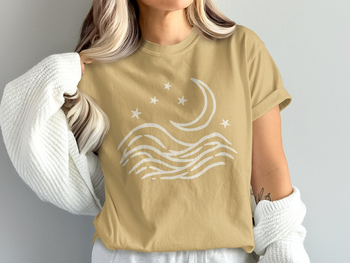 Tan t-shirt with minimalist white moon and stars design over wavy lines.