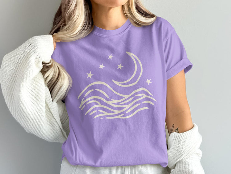 Lavender t-shirt with a cream crescent moon, stars, and wavy lines design.