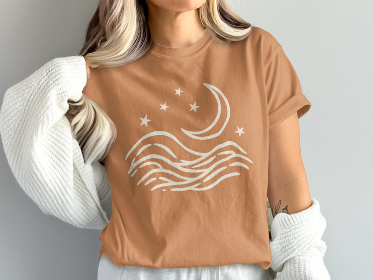 Brown t-shirt with white moon, stars, and wave graphic.