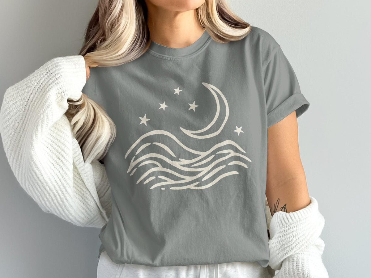 Grey t-shirt with cream crescent moon, stars, and wavy lines design.