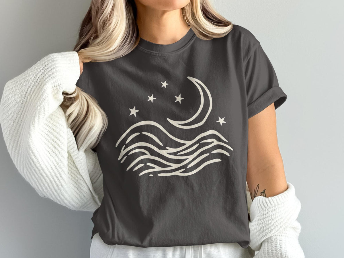 Dark gray t-shirt with a cream abstract moon, stars, and wavy lines design.