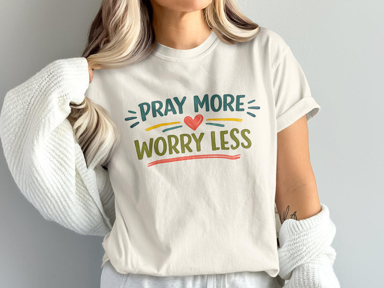 Cream t-shirt with "Pray More Worry Less" text and red heart graphic.