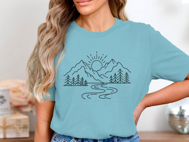 Blue t-shirt with a minimalist line drawing of mountains, trees, river, and sun.