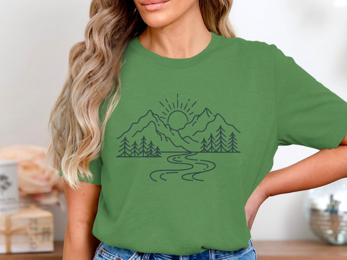 Green t-shirt with a linear mountain, tree, and river nature graphic.