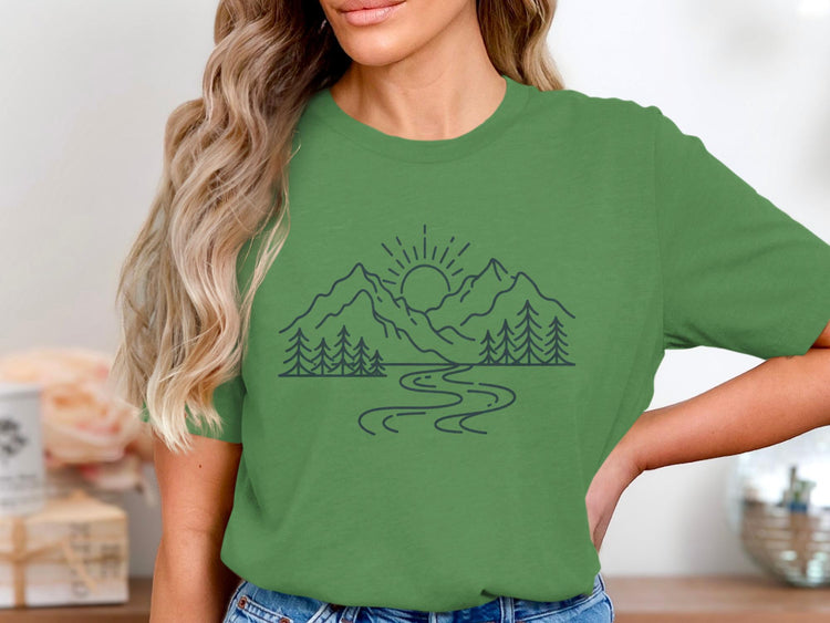 Green t-shirt with a linear mountain, tree, and river nature graphic.