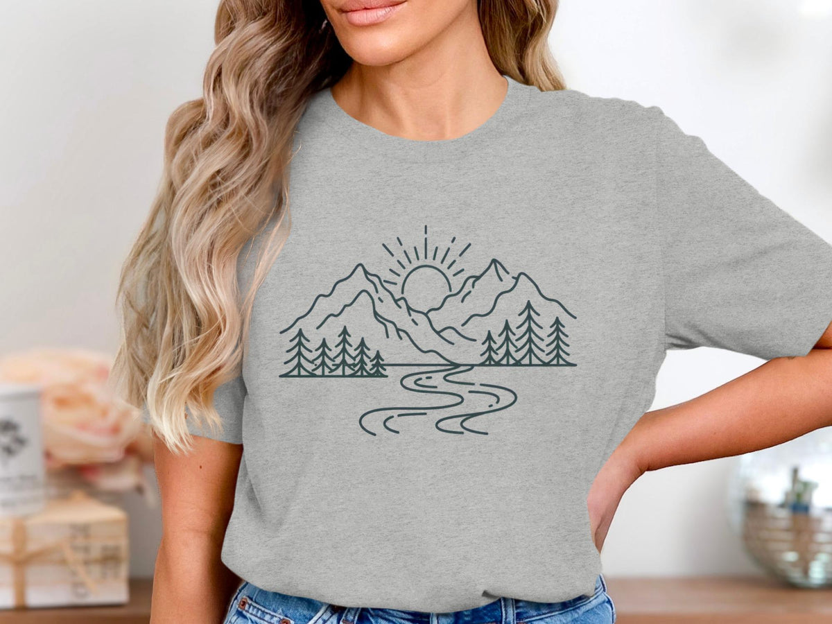 Grey t-shirt with line art of mountains, sun, trees, and a winding river.