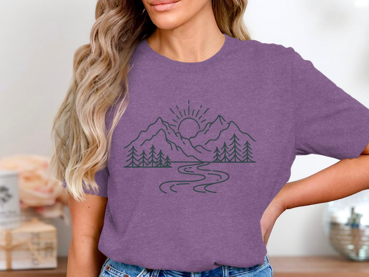 Purple t-shirt with line art of mountains, trees, river, and sun.