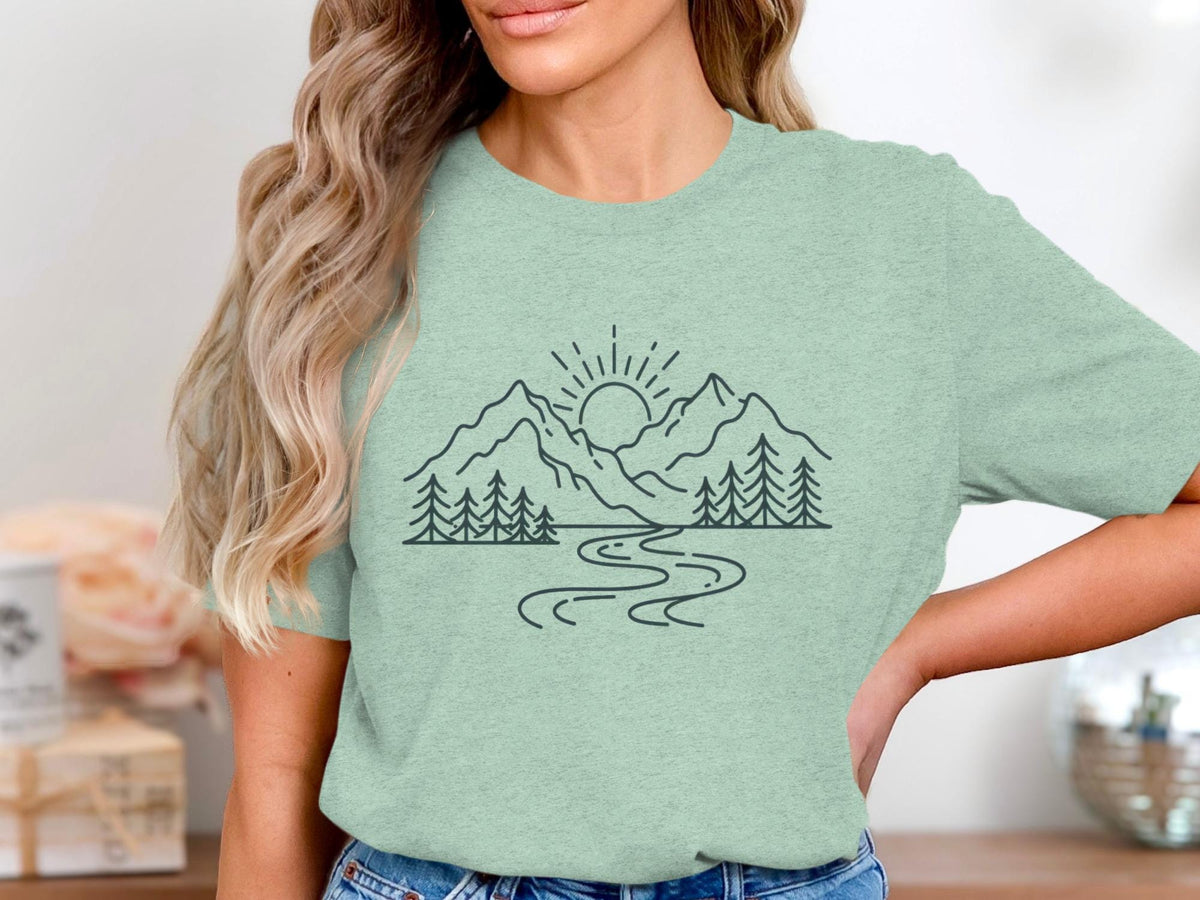 T-shirt with line art of sun, mountains, trees, and a winding river.