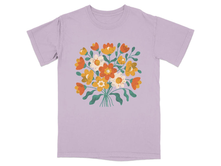 Lavender t-shirt with a vibrant bouquet of orange, yellow, and white flowers.