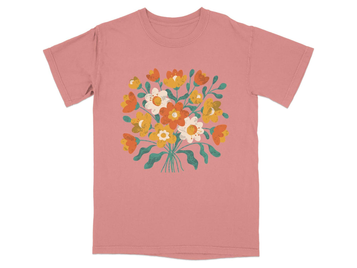 Coral t-shirt with a bouquet of orange, yellow, and white flowers.