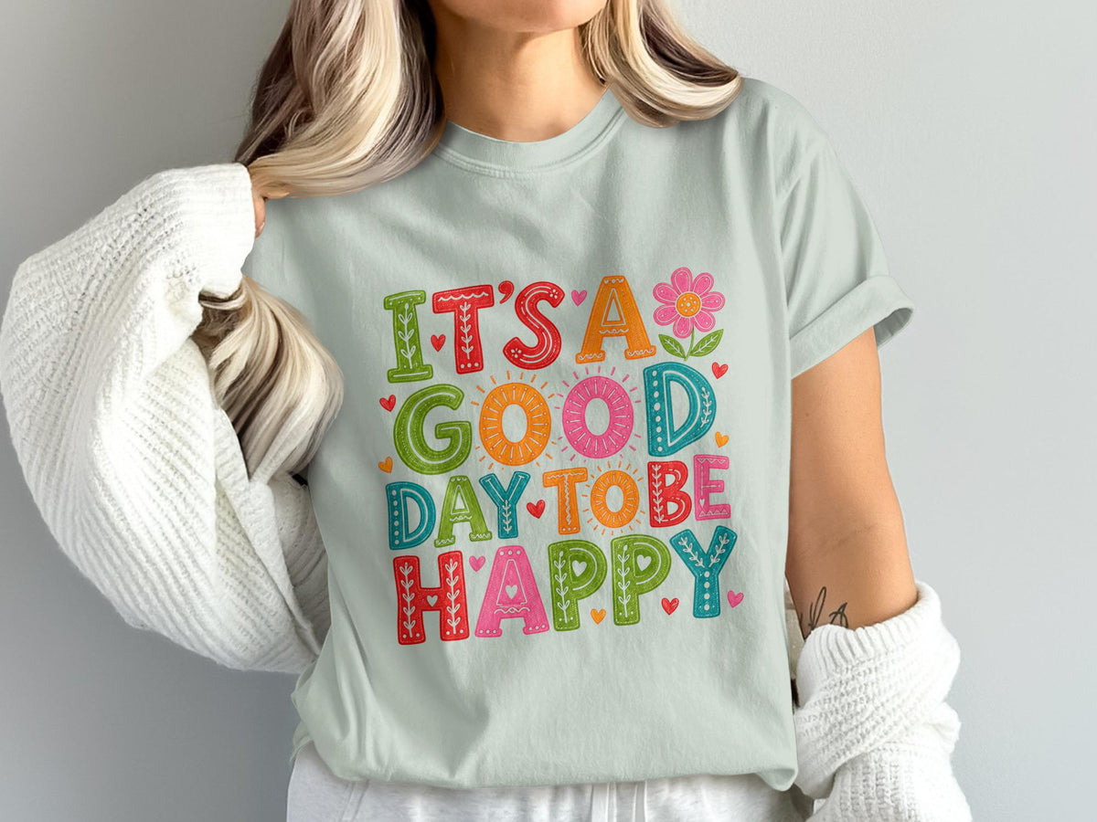 Light blue t-shirt with "It's a good day to be happy" in colorful, decorative lettering.