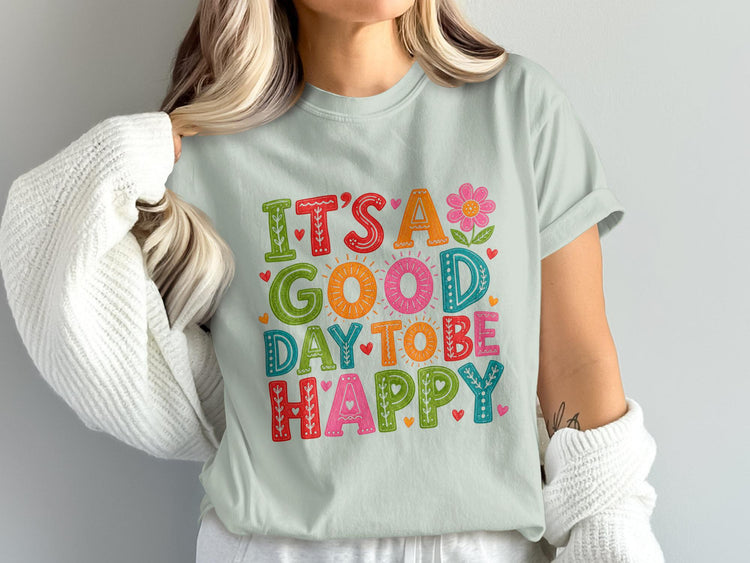 Light blue t-shirt with "It's a good day to be happy" in colorful, decorative lettering.