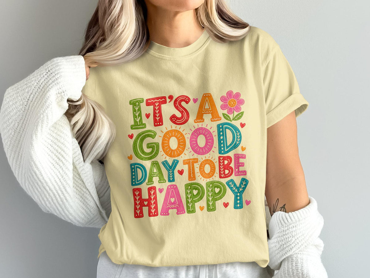 Light yellow t-shirt with "IT'S A GOOD DAY TO BE HAPPY" text and colorful floral accents.