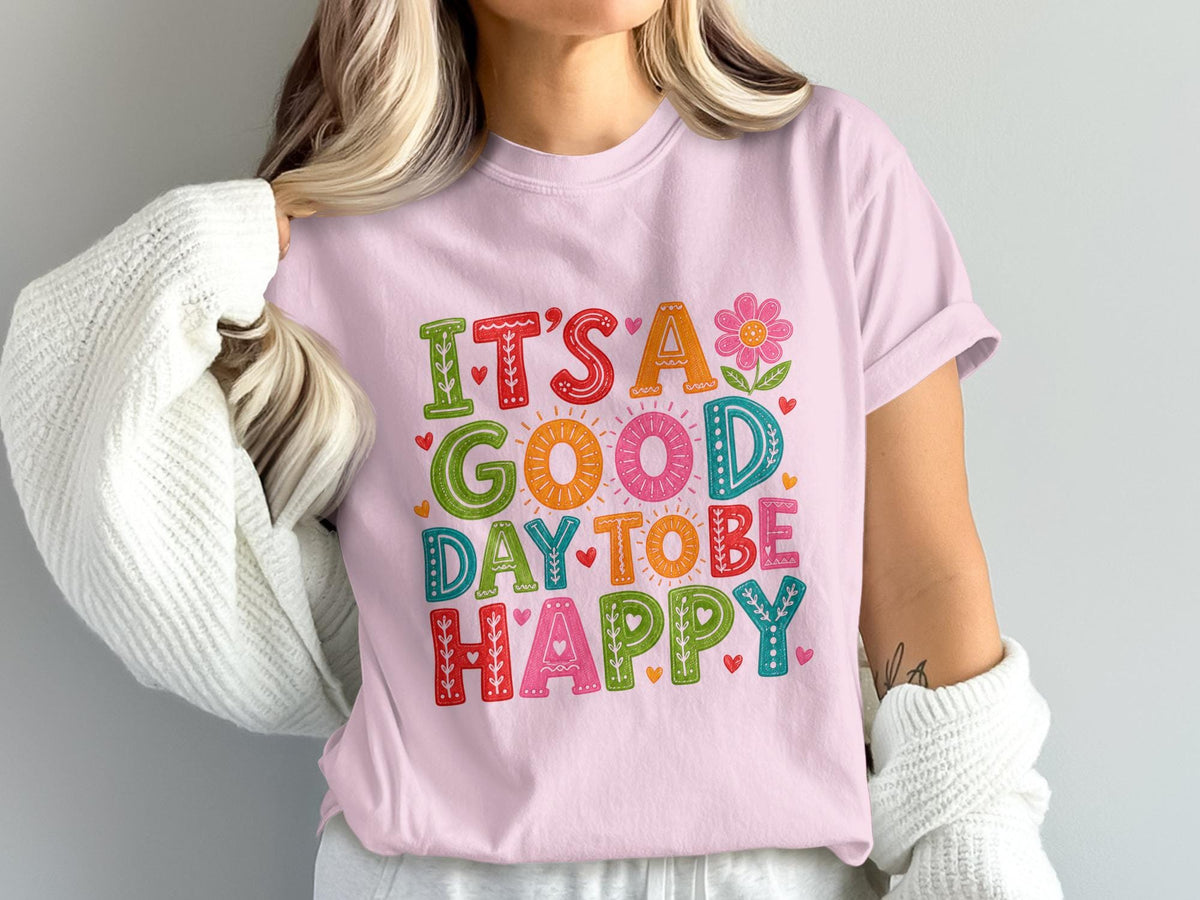 Pink t-shirt with colorful "It's a good day to be happy" text and design.