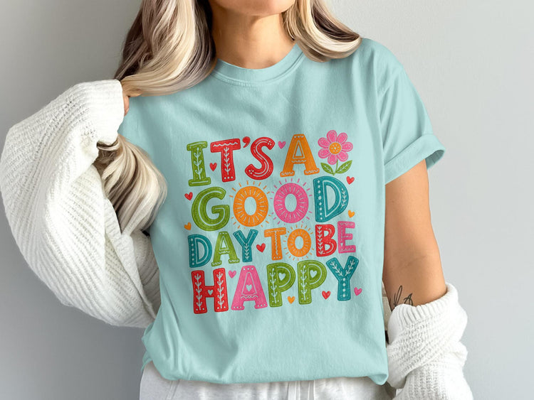 Light blue t-shirt with colorful text that reads "It's a good day to be happy"