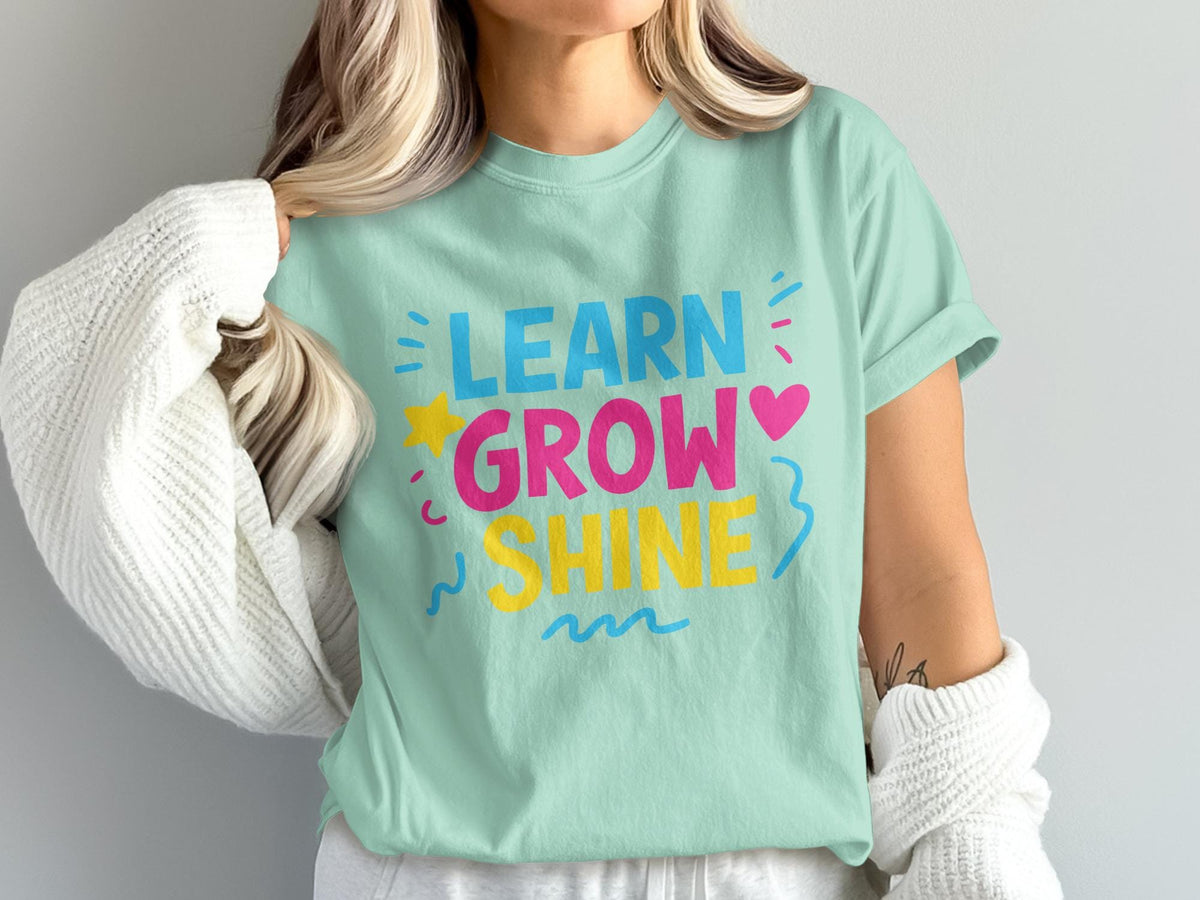 Mint green t-shirt with "LEARN GROW SHINE" text in blue, pink, and yellow.