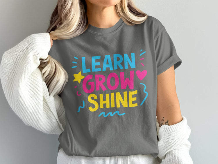 Gray t-shirt with "LEARN GROW SHINE" text and colorful embellishments.