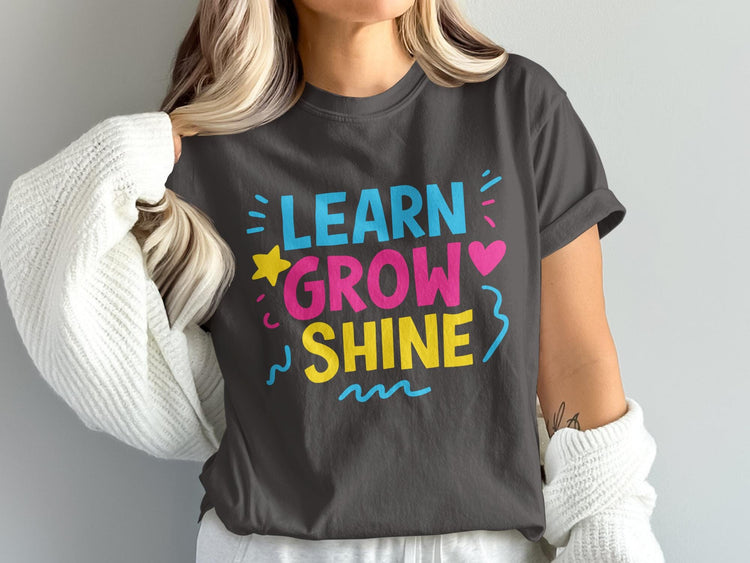 T-shirt with "LEARN GROW SHINE" text in bright colors and graphic elements.