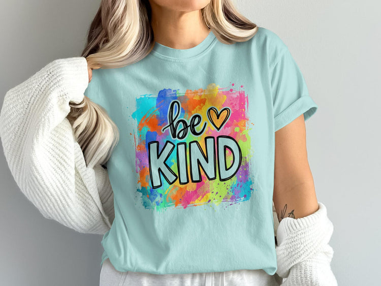 Light blue t-shirt with "be ♡ KIND" text in colorful watercolor splash design.