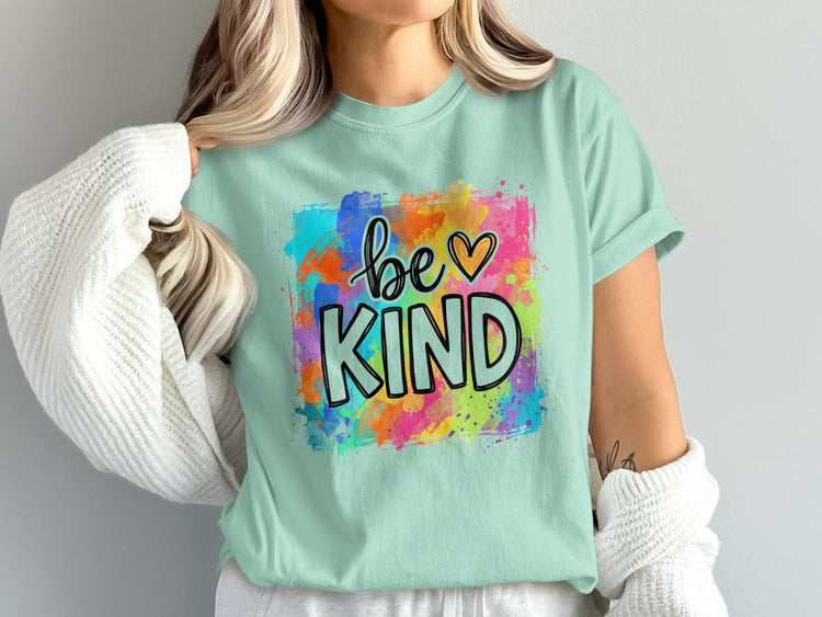 Mint green t-shirt with colorful abstract background and "be KIND" text.