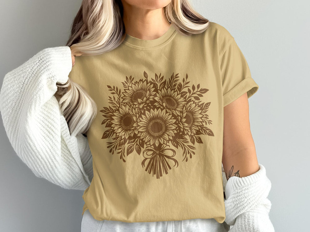 Brown sunflower bouquet graphic on a tan t-shirt worn by a person.