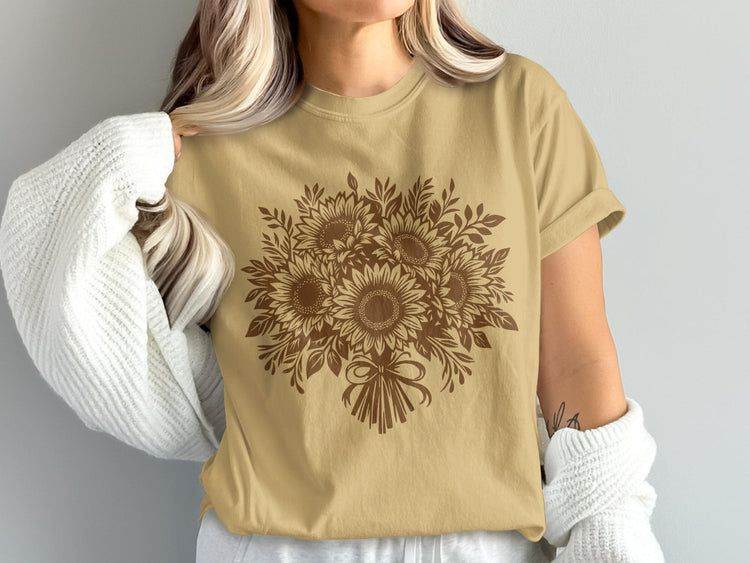 Brown sunflower bouquet graphic on a tan t-shirt worn by a person.