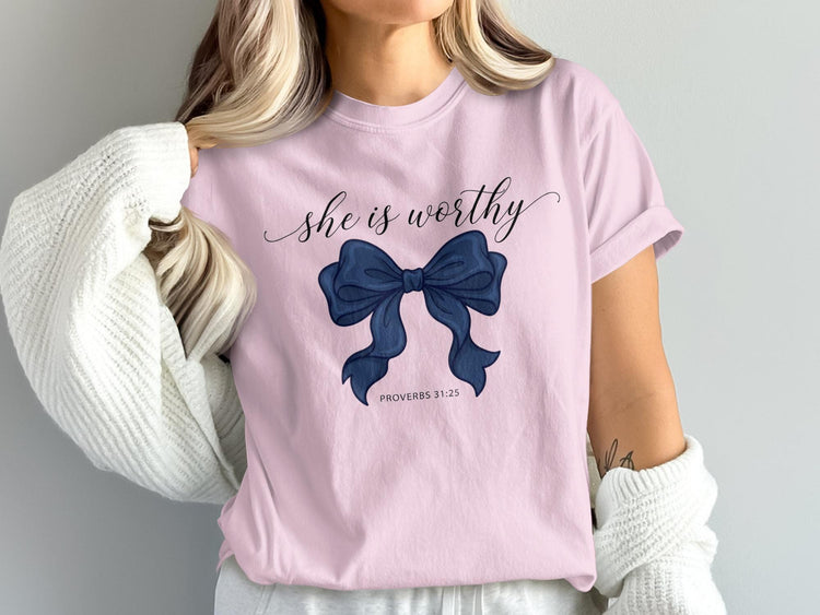 Pink t-shirt with navy bow graphic and "she is worthy PROVERBS 31:25" text.