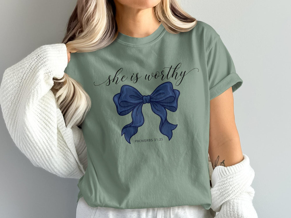 Green t-shirt with "she is worthy" and a blue bow, Proverbs 31:25.