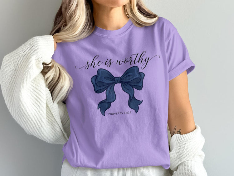 Lavender t-shirt with "she is worthy" and a blue bow graphic.