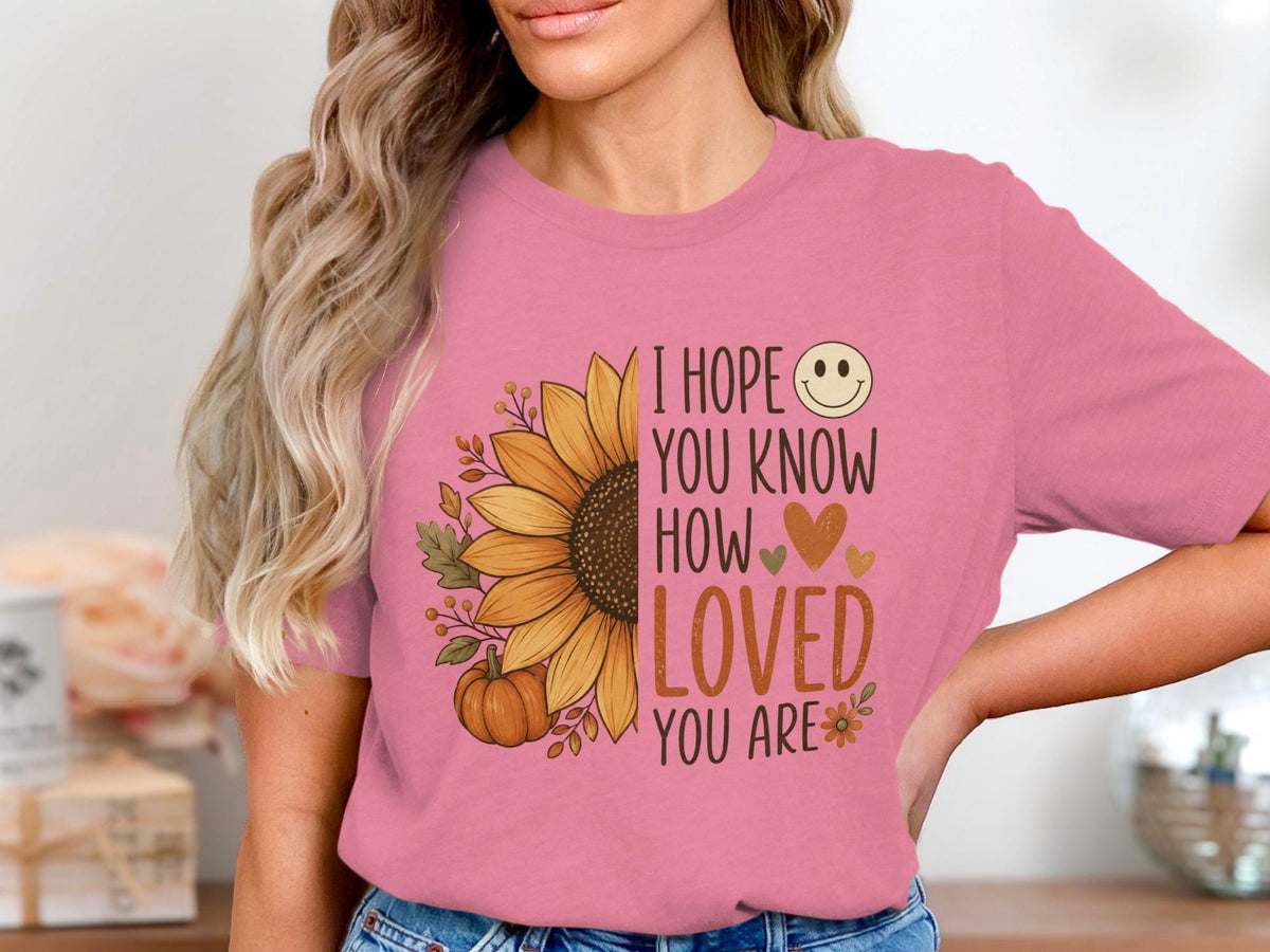 Pink t-shirt with sunflower graphic and text "I hope you know how loved you are".