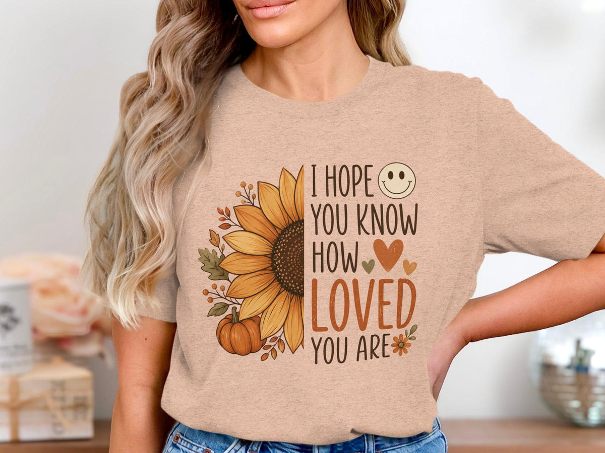 Peach t-shirt with sunflower, pumpkin, leaves, and text "I HOPE YOU KNOW HOW LOVED YOU ARE".