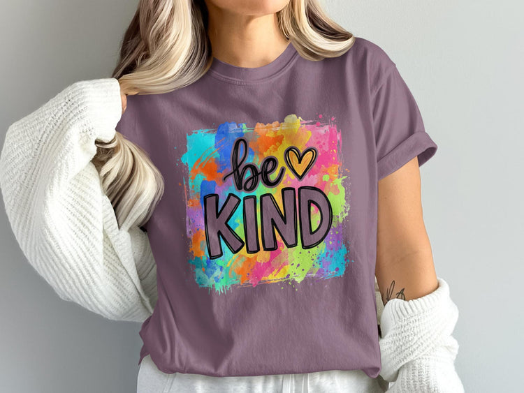 Purple t-shirt with colorful watercolor background and text "be KIND"