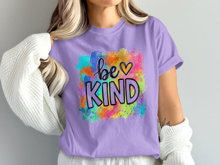 Lavender t-shirt with colorful watercolor splatter and "be KIND" text with heart.