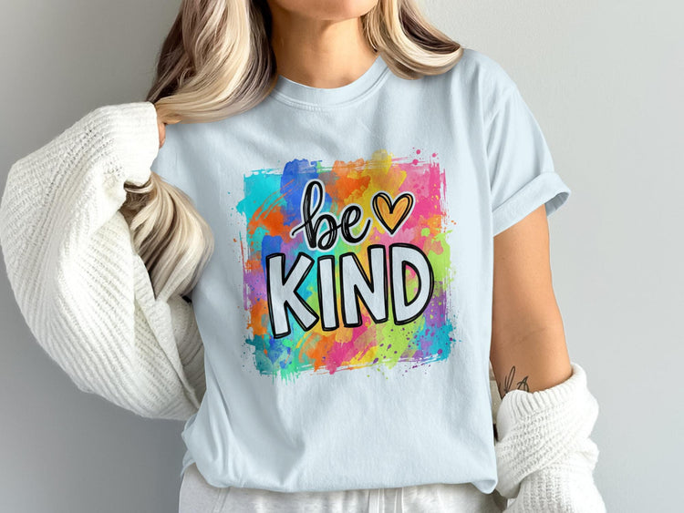 Light blue t-shirt with "be KIND" graphic on colorful watercolor splatters.