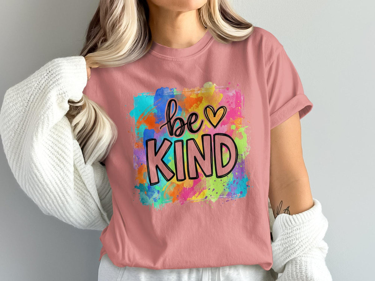 Pink t-shirt with "be KIND" text and colorful watercolor splash design.