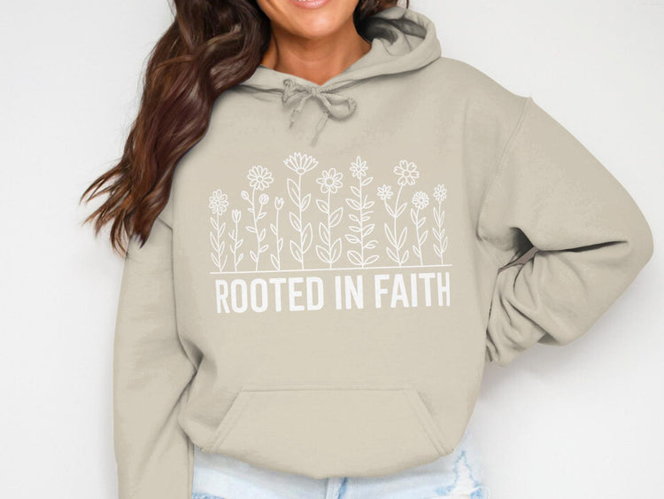 Tan hoodie with white floral design and "ROOTED IN FAITH" text.