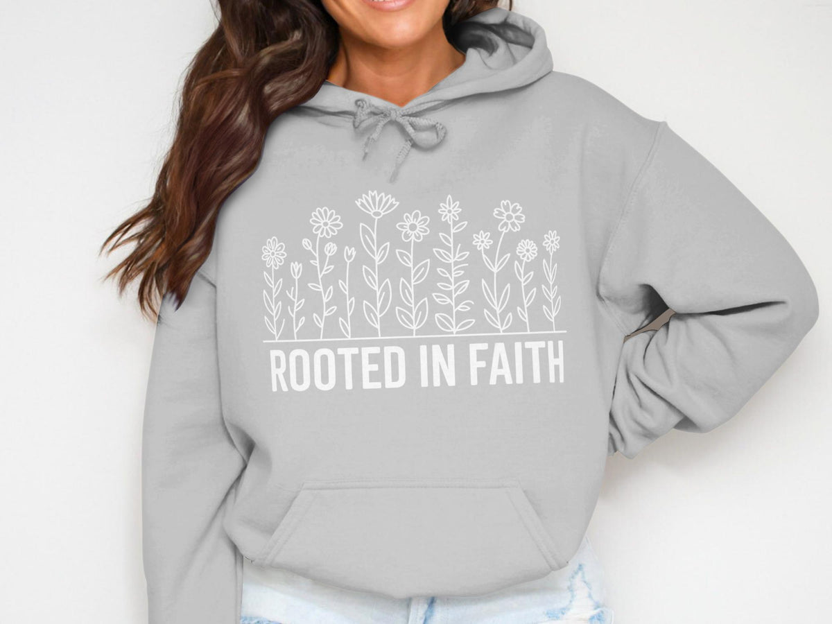 Grey hoodie with white floral design and "ROOTED IN FAITH" text.