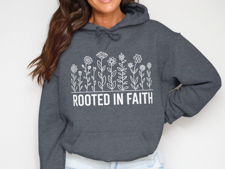 Dark grey hoodie with white floral design and text "ROOTED IN FAITH".