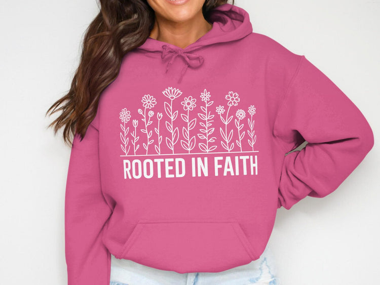 Pink hoodie with white flowers and "ROOTED IN FAITH" text.