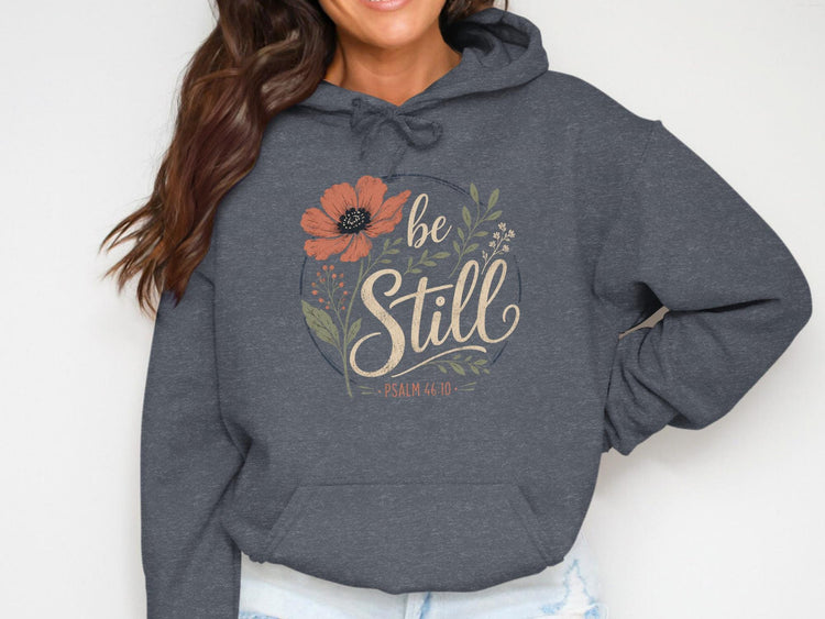 Dark grey hoodie with a floral circle graphic that says "be Still" and "Psalm 46:10".