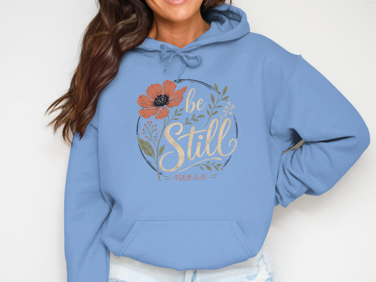 Light blue hoodie with floral design and "be Still Psalm 46:10" text.