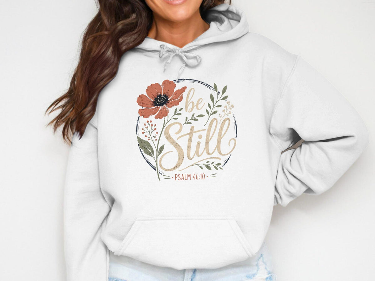 White hoodie with floral design and text "Be Still Psalm 46:10".