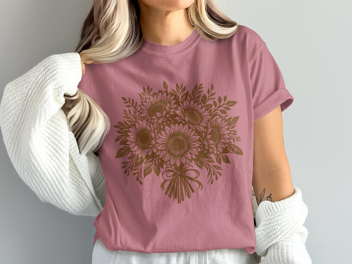 Pink t-shirt with a brown sunflower bouquet graphic and a white knit sweater.