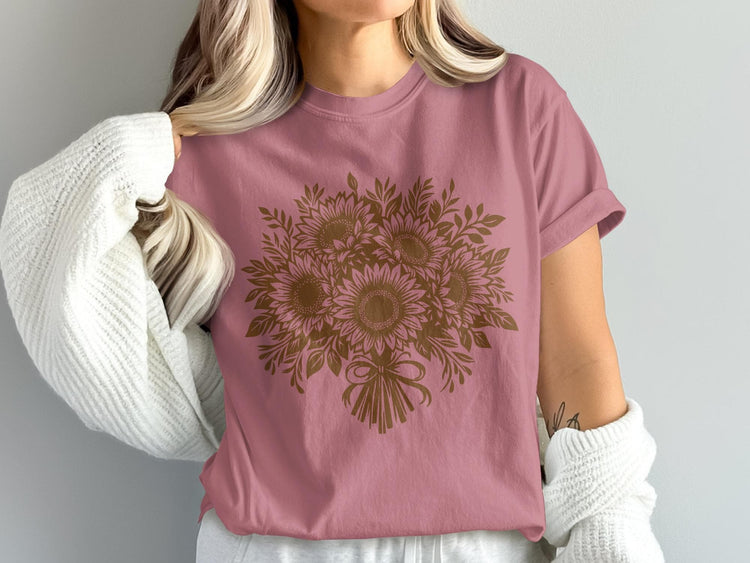 Pink t-shirt with a brown sunflower bouquet graphic and a white knit sweater.