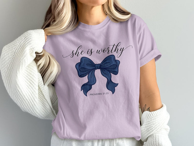 Lilac t-shirt with "she is worthy" and a navy blue bow, Proverbs 31:25.