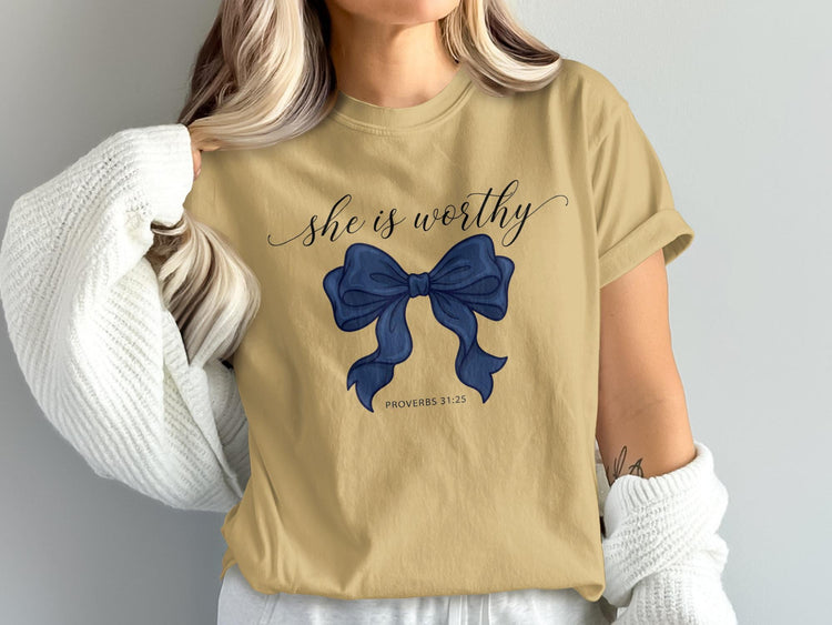 T-shirt with "she is worthy" and a blue bow graphic with "PROVERBS 31:25".