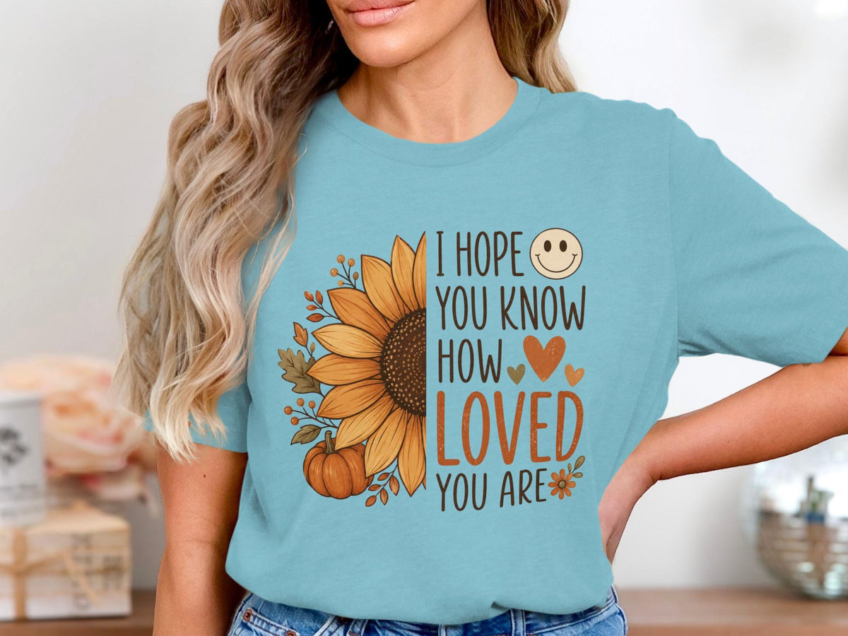 Light blue t-shirt with sunflower, pumpkin, and "I hope you know how loved you are" text.
