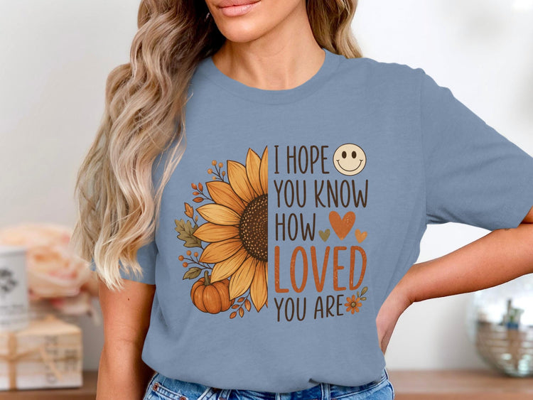 Blue t-shirt with sunflower, pumpkin, leaves, and text: "I hope you know how loved you are."